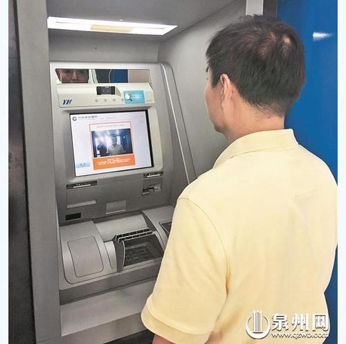中国侨网银行工作人员演示刷脸取款流程