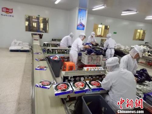 中国侨网阿一波生产车间一角，图为员工正在包装紫菜准备上市。　梁挺帅　摄