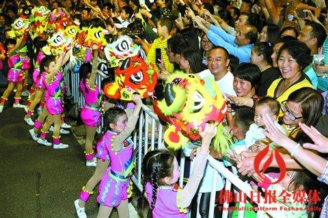 中国侨网秋色巡游中，佛山市铁军小学的同学们扎作的狮头，受到市民热捧。/佛山日报记者甘建华摄