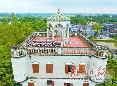 中国侨网“世遗侨都·天籁大歌”两个世界级文化遗产的“约会”是2017中国侨都(江门)华人嘉年华的一大亮点活动。图为来自贵州黔东南的姑娘在开平碉楼表演现场。马立敏 摄