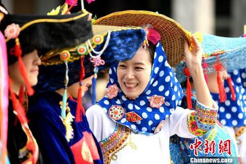 中国侨网惠安女为防风而佩带花色头巾和橙黄色的斗笠。　王东明 摄