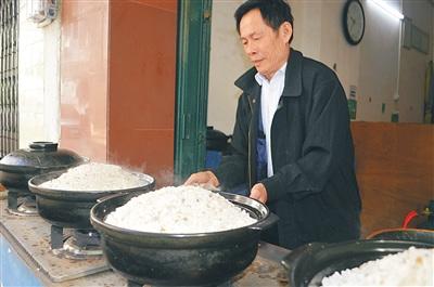 中国侨网潘正晖在烹制盐焗鸡。