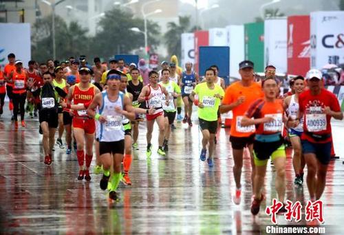 中国侨网参赛选手雨中开跑。 王东明 摄