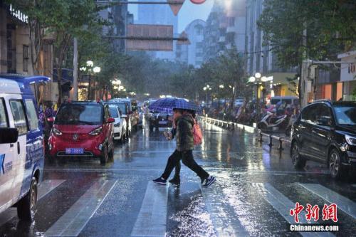 中国侨网1月6日,广西柳州市遭遇了小寒后的强降雨天气,温度骤降,市民纷纷穿上了大棉衣、撑伞出行。 王以照 摄