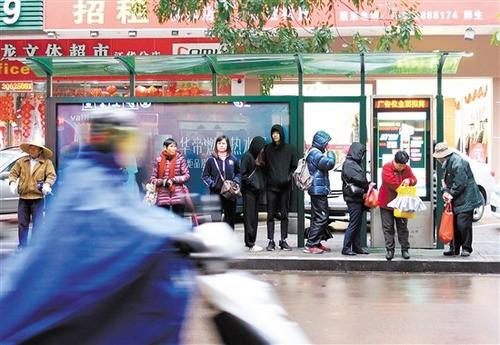 中国侨网公交站台，在寒风中的市民盼着公交车快点到来。 