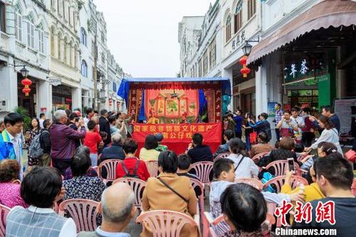中国侨网春节期间，海口骑楼老街为游客带来颇具本地特色的海南公仔戏表演。　罗长英　摄