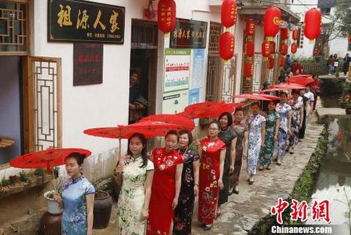中国侨网图为旗袍表演队走过村庄。　程向阳　摄