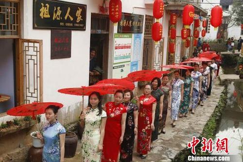 中国侨网图为旗袍表演队走过村庄。 程向阳 摄