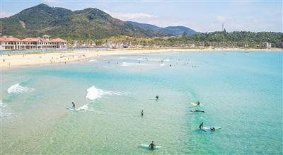 中国侨网游客在万宁日月湾学习冲浪，他们在浪尖跳跃、冲刺，展示矫健身姿，享受假日时光。本报记者 袁琛 摄