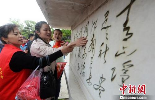 中国侨网图为盲人触摸廋西湖景区熙春台前的诗碑。　孟德龙　摄