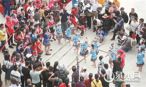 中国侨网14日，在厝斗村，村民身穿畲族传统服饰跳起《竹竿舞》，吸引了许多游客。	（张九强 摄）