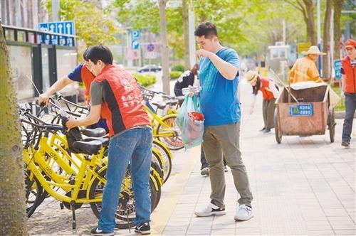 中国侨网义工在整理共享单车。郭永乐 摄