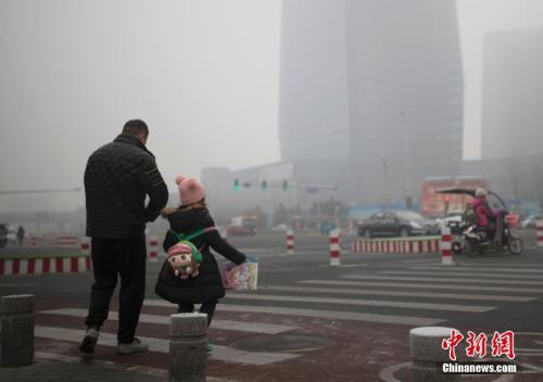 中国侨网资料图：北京市民在雾霾中出行。中新社记者 刘关关 摄