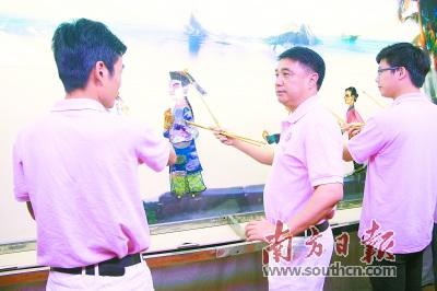 中国侨网蔡劲笋(中)对传承潮俗皮影非常执着。受访者供图
