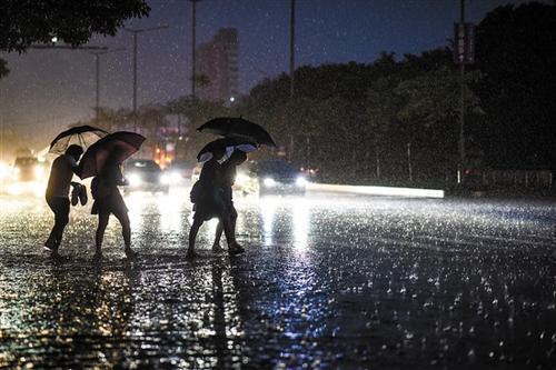 中国侨网7日19:02，黄埔大道中，路人在暴雨中涉水而行 羊城晚报记者 宋金峪 摄