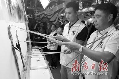 中国侨网蔡劲笋(右一)在文博会主会场大鹏展区表演皮影戏。 南方日报记者 朱洪波 摄