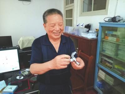 中国侨网郑祥青介绍他自己发明的新式水龙头。