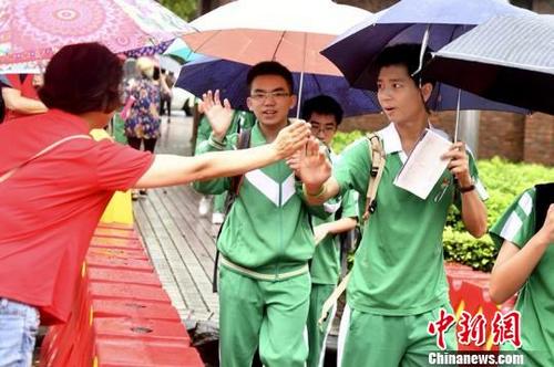 中国侨网高考首日，今天广州迎来强降雨，7万余名考生雨中奔赴60个考点参加高考。　陈骥旻　摄