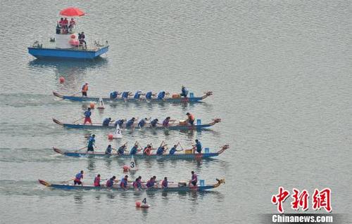 中国侨网 龙舟在三峡大坝前的湖北省秭归县徐家冲港湾水域比拼 雷勇 摄