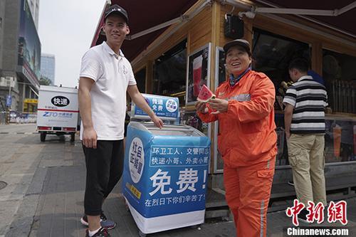 中国侨网8月4日，环卫工人在北京街头的“爱心冰箱”取用西瓜。 中新社记者 贾天勇 摄