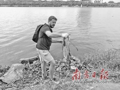 中国侨网Olivier在江边捡拾垃圾。受访者供图