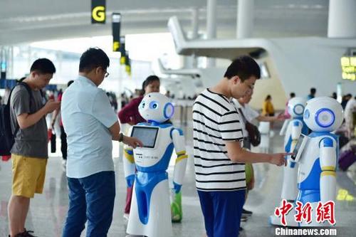 中国侨网广州白云机场上线“云朵”智能机器人，可多语种交互，吸引众多旅客的注意　王婧　摄