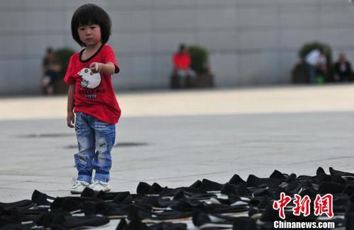 中国侨网9月18日，在沈阳“九一八”历史博物馆残历碑东侧起到展馆入口处呈“S”型的步道上，整齐摆放着数千双黑色的布鞋，为纪念二战期间在日本遇害的6000余名中国劳工。　于海洋　摄