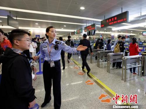 中国侨网边检工作人员正引导旅客进入新建的自助通道。　邓楠楠　摄