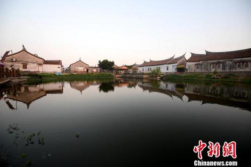 中国侨网整片古厝群恰似飘浮在河面上，夕阳泛舟，古厝映影，形成独特景观。　张斌　摄