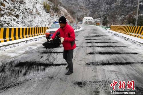 中国侨网撒盐溶雪确保来往车辆安全。宜昌交通 供图