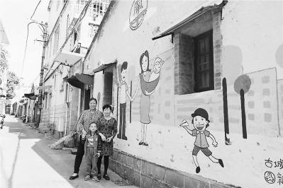 中国侨网图为近日，社区居民在彩绘墙前合影。　施远圻　摄影报道