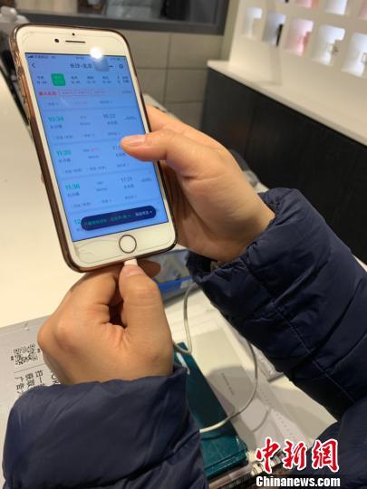 中国侨网12月24日，长沙某商场一导购员在忙碌间隙查询车票信息。　鲁毅　摄