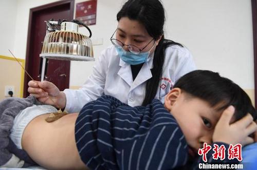 中国侨网图为医务人员正在对一位小孩进行“三九灸”。　张斌　摄