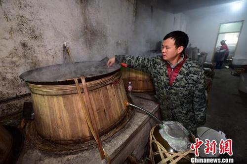 中国侨网图为村民在“扶贫酒坊”测试蒸馏锅冷却水水温。 杨武魁 摄