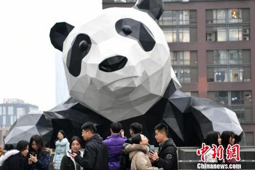 中国侨网一些情侣来到大熊猫雕塑前合影。　张浪　摄