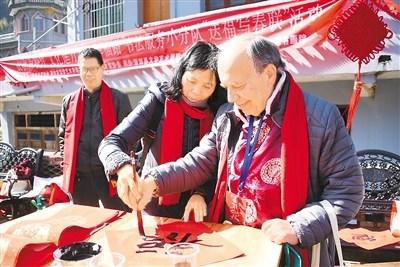 中国侨网 春联，是过年的象征，是文化的传承。国际友人跟着师傅们拿起毛笔，学写春联和“福”字。     