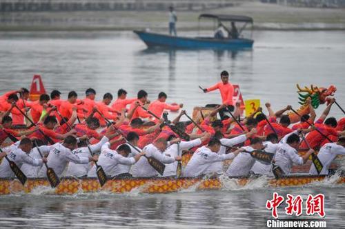 中国侨网3月7日，2019中华龙舟大赛(海南·万宁站)在海南万宁市和乐镇港北港鸣锣开赛。图为参加22人100米直道赛选手正在比赛中。　骆云飞　摄