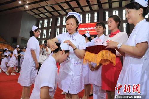 中国侨网前辈为医学生戴上护士帽。刘莉摄