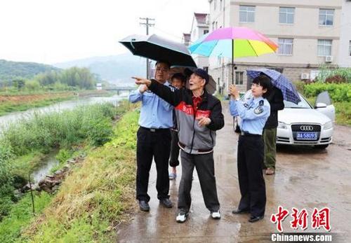 中国侨网图为:民警陪台胞蒋志凡寻找其父亲86年前的安葬地 仙居公安供图