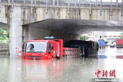 中国侨网停放在涵洞中的货车，泡在水里。　朱柳融　摄