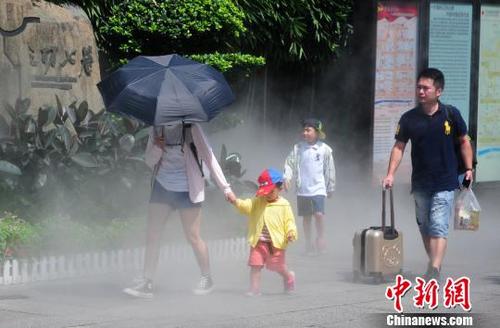 中国侨网图为7月1日，福州三坊七巷喷水雾装置给游客带来一丝凉意。当日，福州市气象台继续发布高温橙色预警信号。　张斌　摄