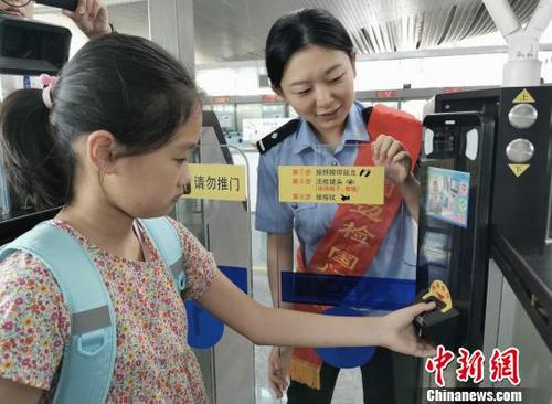 中国侨网工作人员协助儿童使用自助通道。 余熙楚娃 摄