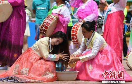 中国侨网身着朝鲜族民族服饰的妇女展示流头、沐浴等民俗。　张瑶　摄
