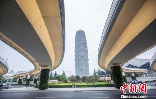 中国侨网“绿衣”与郑州地标建筑物“大玉米”相映成辉，让人耳目一新。　李贵刚　摄