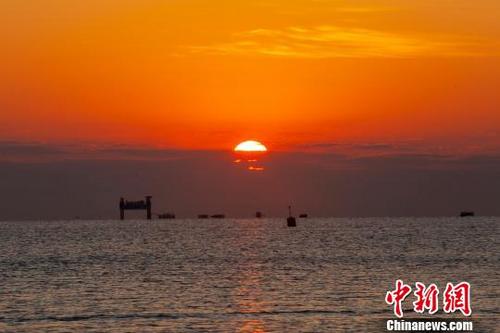 中国侨网清晨时分，一轮红日从海里冒出。　肖丁　摄