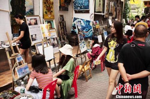 中国侨网图为游客在深圳大芬油画村体验作画。　陈文　摄