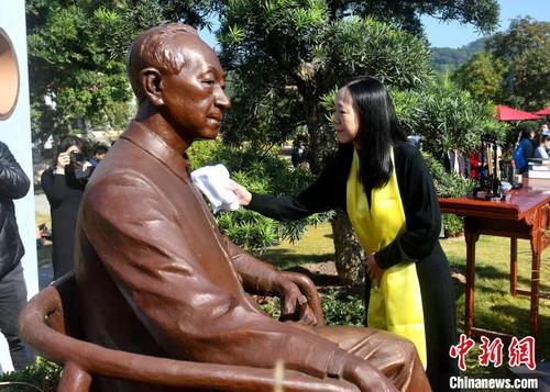 中国侨网图为吴清源弟子牛力力为雕像清洁。 吕明 摄