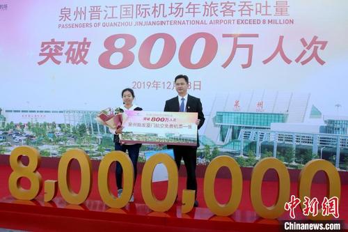 中国侨网12月13日,旅客黄小姐(左)幸运地成为泉州晋江国际机场2019年的第800万名乘客。 叶扬 摄