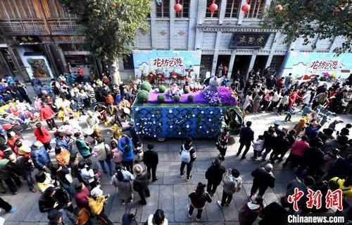 中国侨网1月1日,第二届福州三坊七巷新年花市上演“花车巡游”活动,吸引众多市民游客沉浸在繁花锦簇的古巷里,欢庆2020新年的到来。 刘可耕 摄