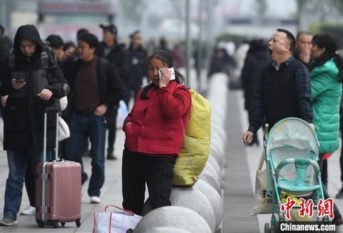 中国侨网图为一旅客背着大包行李准备进站乘车。　陈超　摄